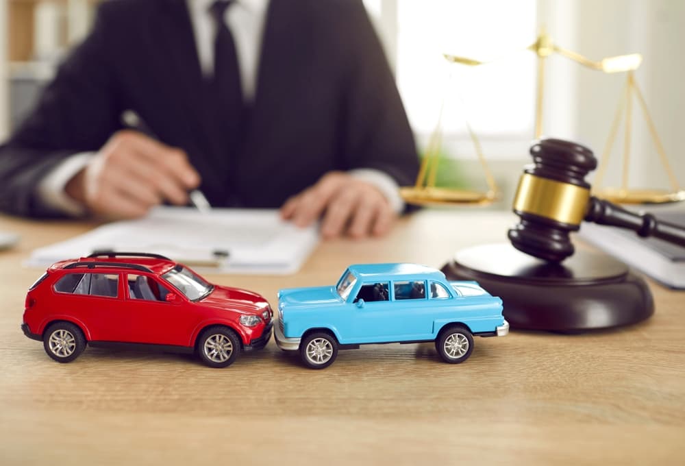 Miniature cars and judge gavel on desk of lawyer