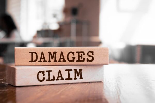 Damages & Claim written on wood block