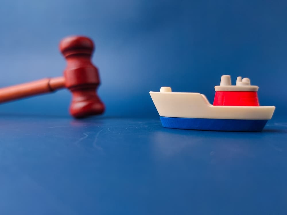 The image shows a gavel and a toy boat,