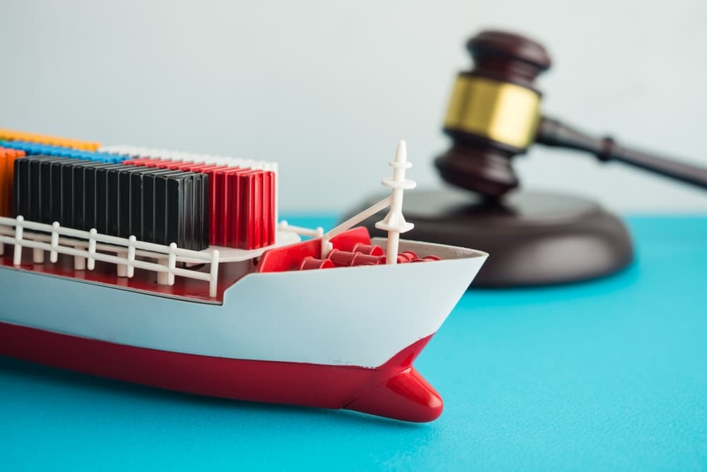 Container cargo ship with hammer judge gavel background.